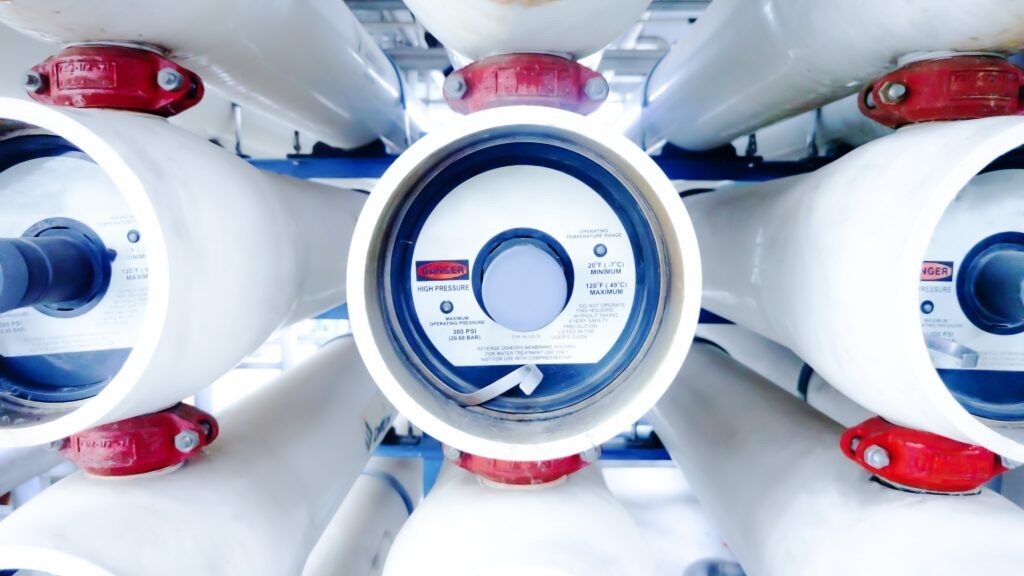Vue rapprochée des tubes de pression contenant les membranes d'osmose inverse d'une station professionnelle